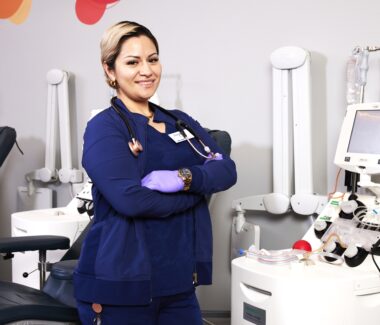 Smiling MBC phlebotomist standing with arms folded.